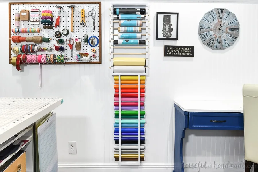 Colorful and organized craft room with storage solutions for craft supplies and vinyl rolls. 