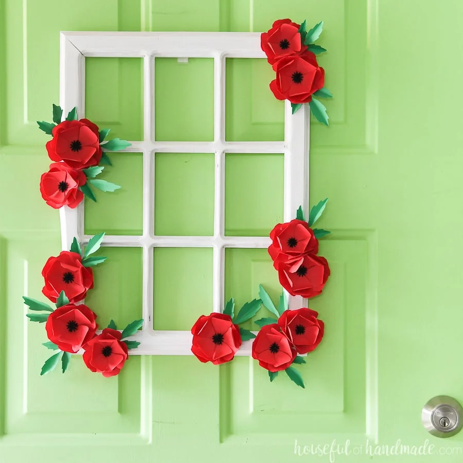 Beautiful white window frame wreath decorated with red poppies made from paper.