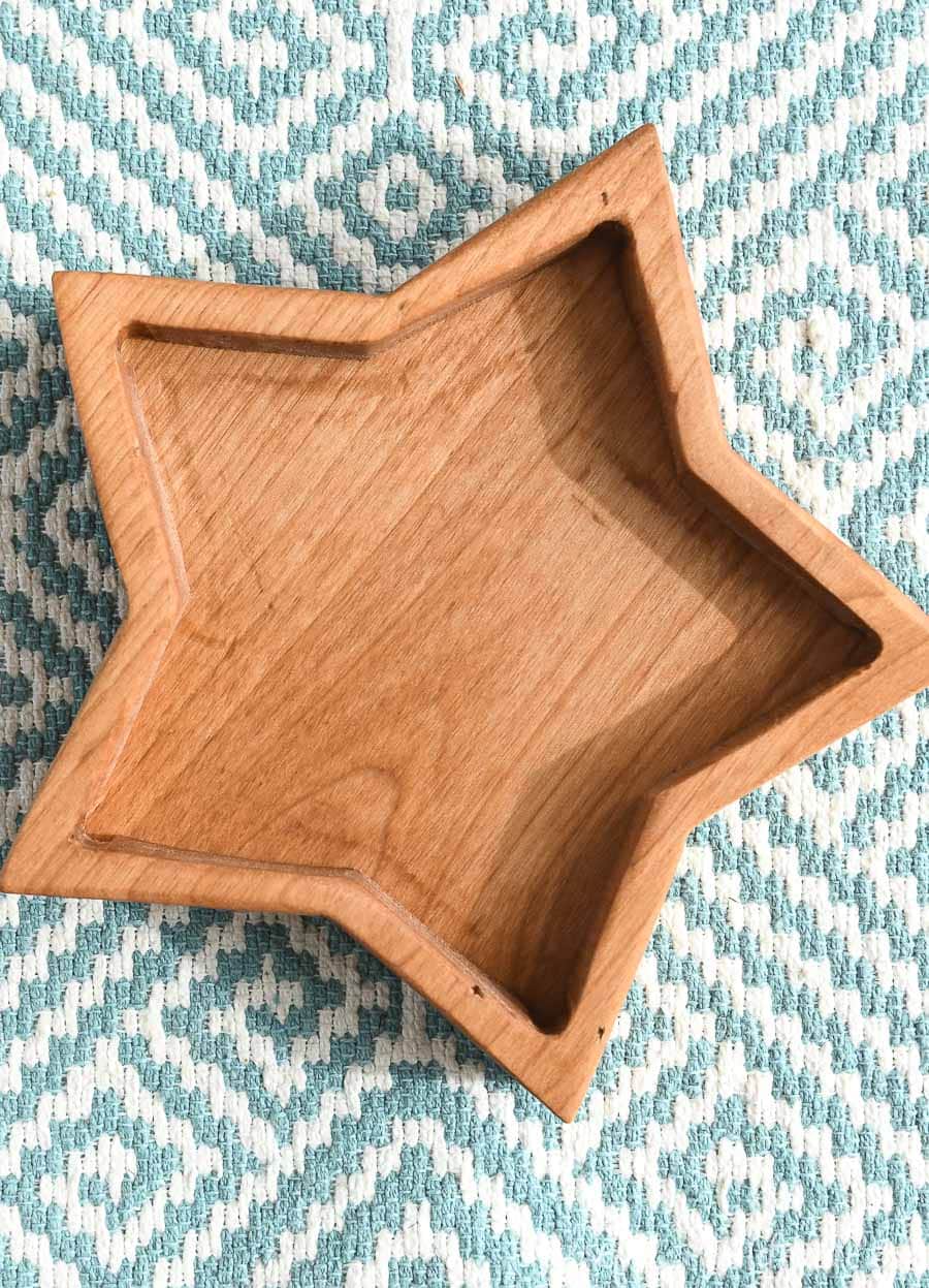 One wood star shaped box on a blue and white fabric background