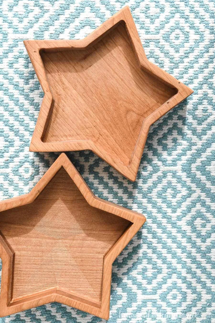 Two wooden star bowls on a blue and white placemat