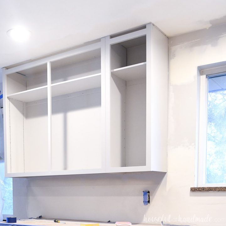 Upper kitchen cabinets painted with a light gray paint.