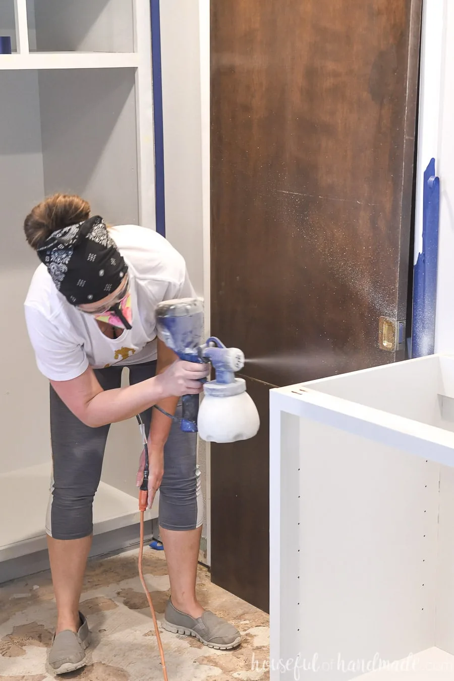 Painting kitchen cabinets with a paint sprayer. 