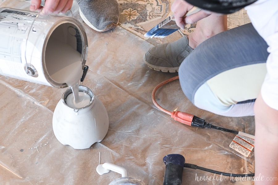 Putting paint into the paint sprayer through a strainer. 