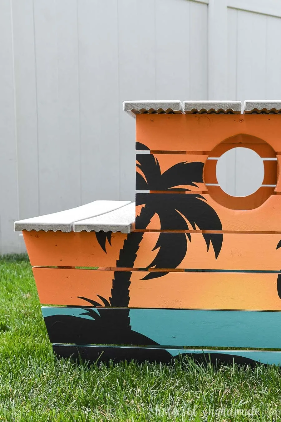 Straight on view of the tropical painted picnic table with a palm tree silhouette. 