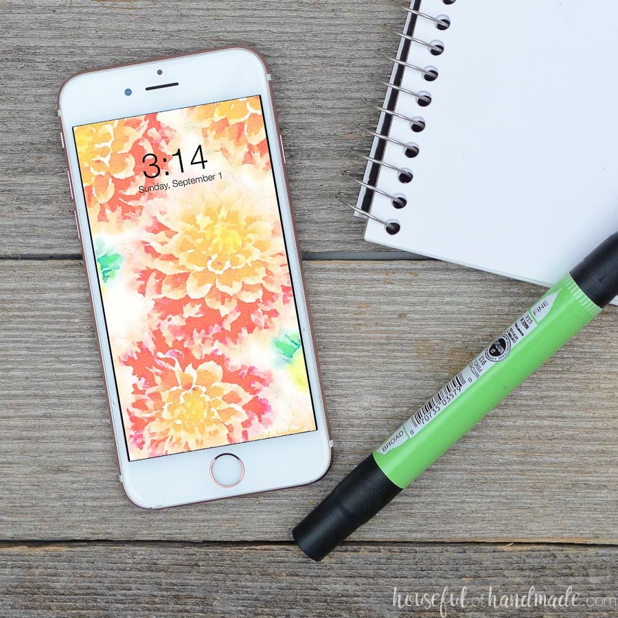 White iPhone on reclaimed wood table with September digital background on the screen.