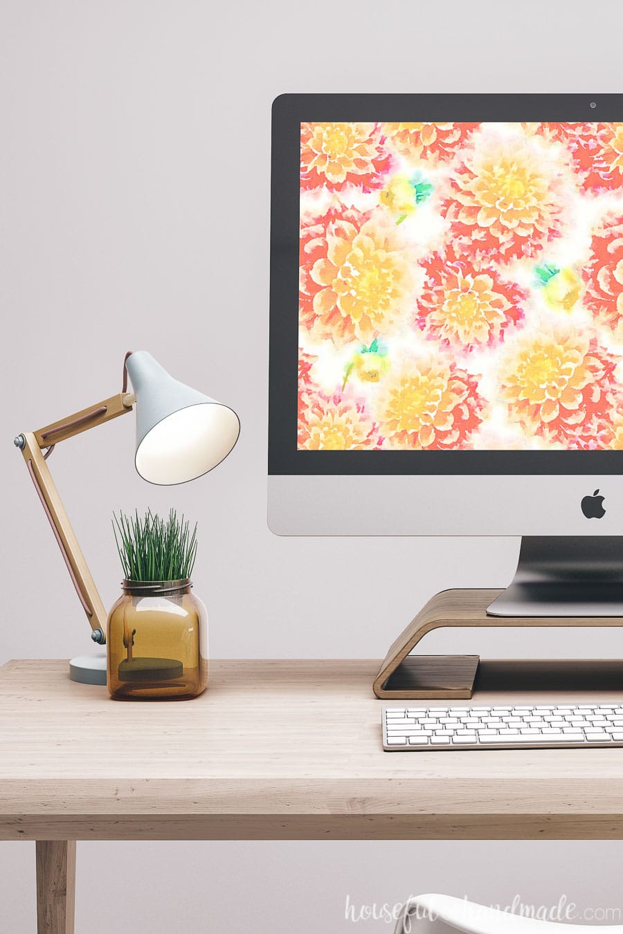 Desk showing part of a computer with the watercolor dahlia digital wallpaper on the screen.