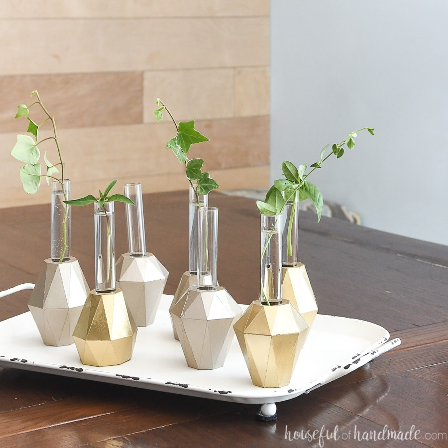 Gold propagation vases on a table with clipping in them.