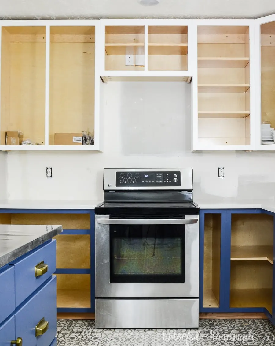 Learn how to build cabinets like these white and blue cabinets around the stove in our kitchen remodel.