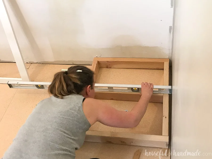 Leveling a 2x4 base to act as the toe kicks for the base cabinets in a kitchen.