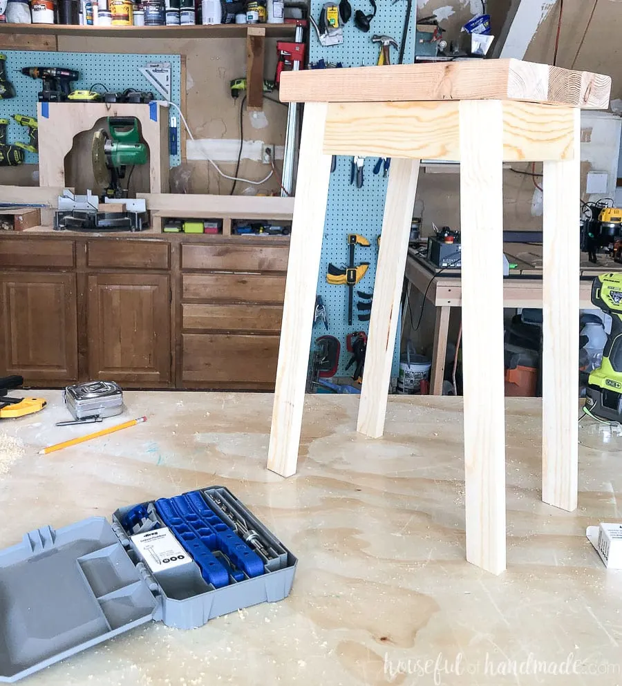 Garage workshop table with finished plant stand on it next to the Kreg 320 pocket hole jig. 