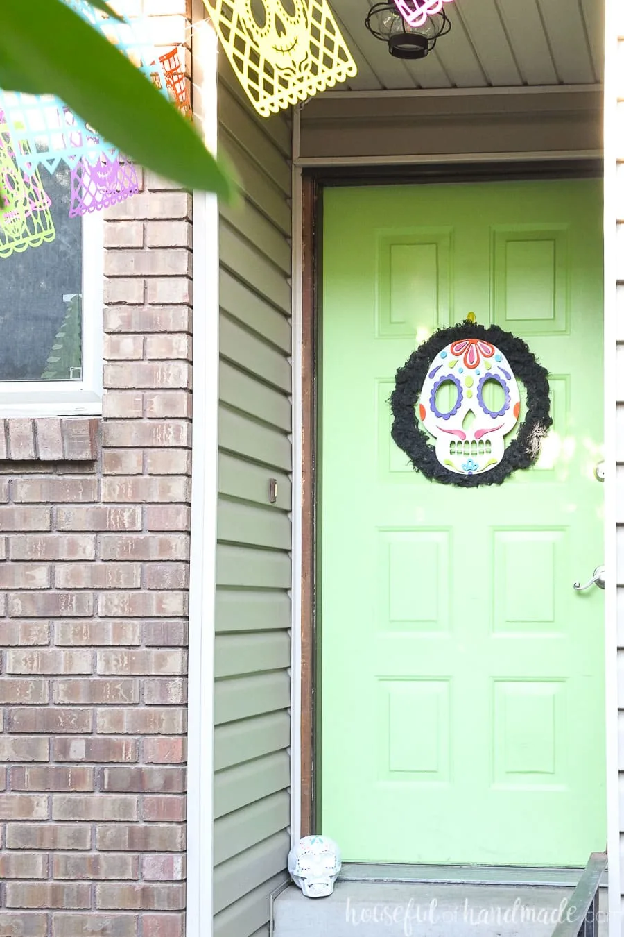 Front entry with a door decorated for Halloween in Day of the Dead theme. 
