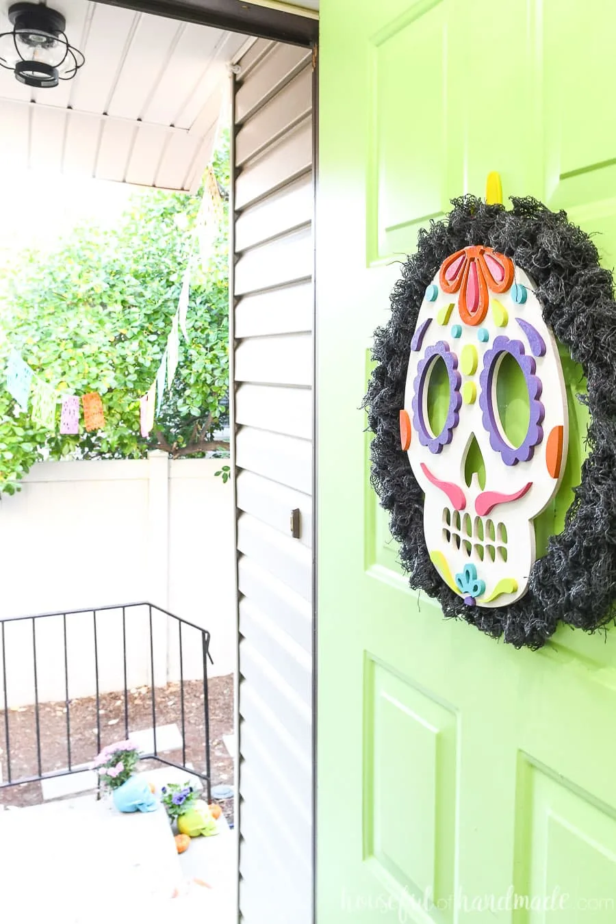 Front door open with sugar skulls wreath hanging on it. 
