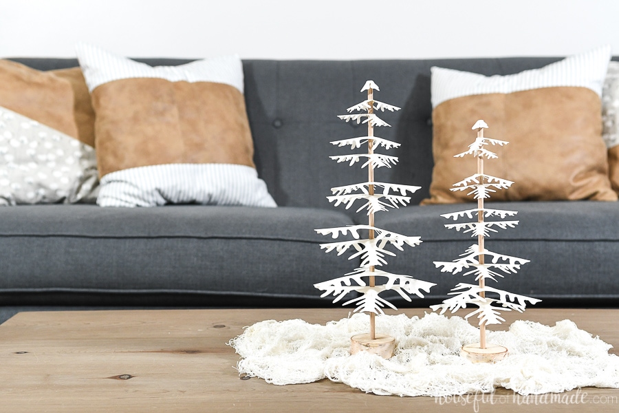 Two handmade decorative Christmas trees on the coffee table with white branches.