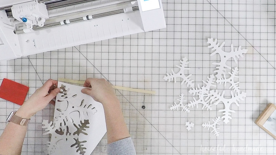 Decorative paper Christmas tree branches cut out of white glitter cardstock with a Silhouette Cameo.