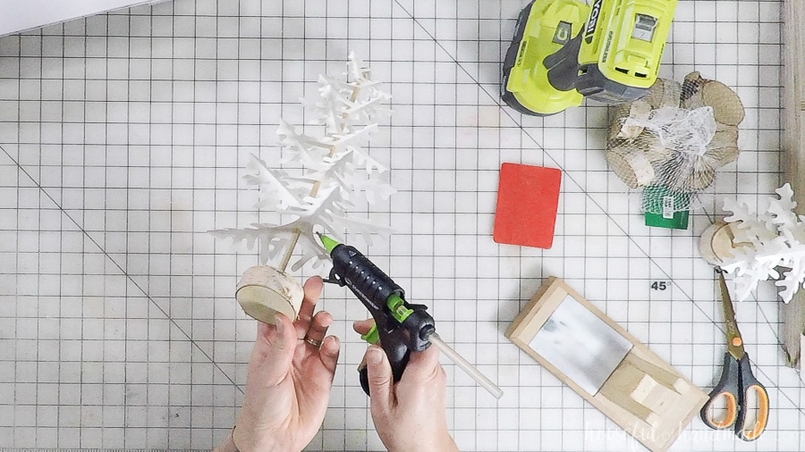 Adding glue to the underside fo the paper Christmas tree branches to secure.