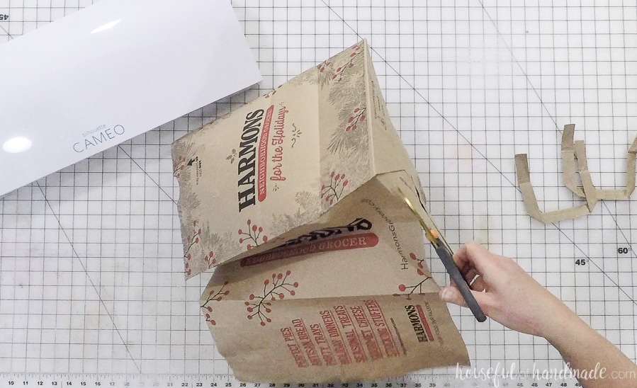 Cutting open the grocery bag to make paper napkin rings.