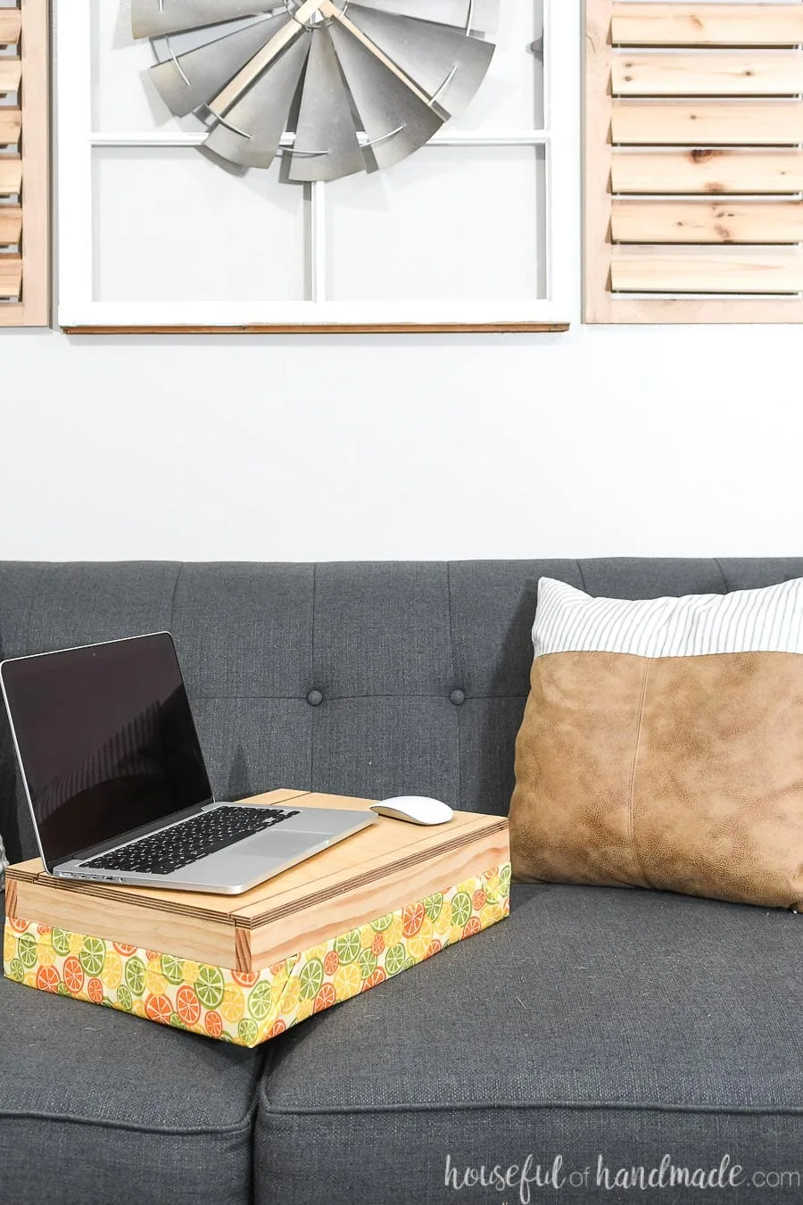 Homemade lap desk with storage on the couch with a laptop on it. 