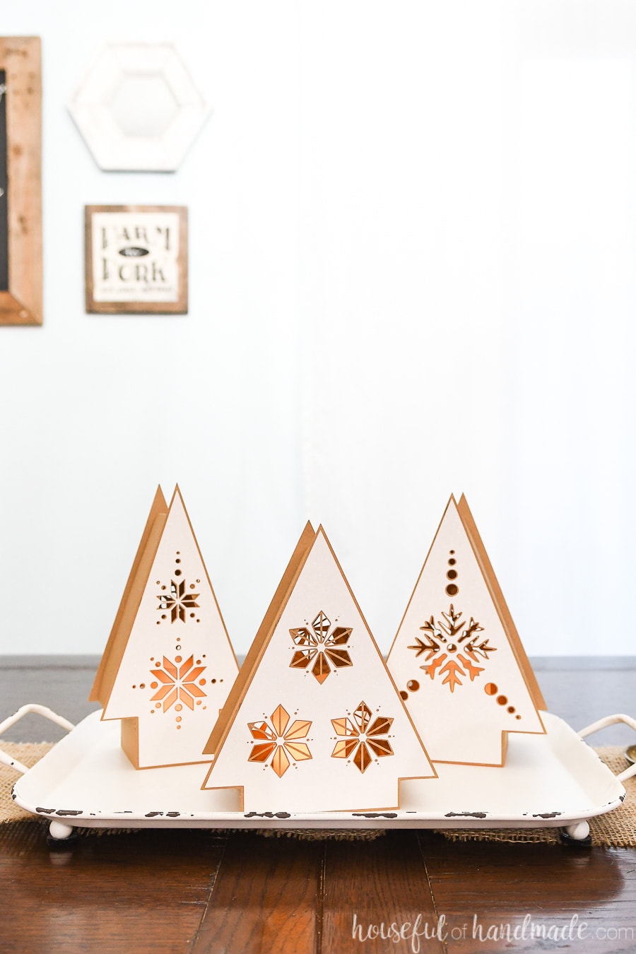 Christmas table centerpiece made of 3 Nordic paper Christmas tree shaped lanterns on a tray.