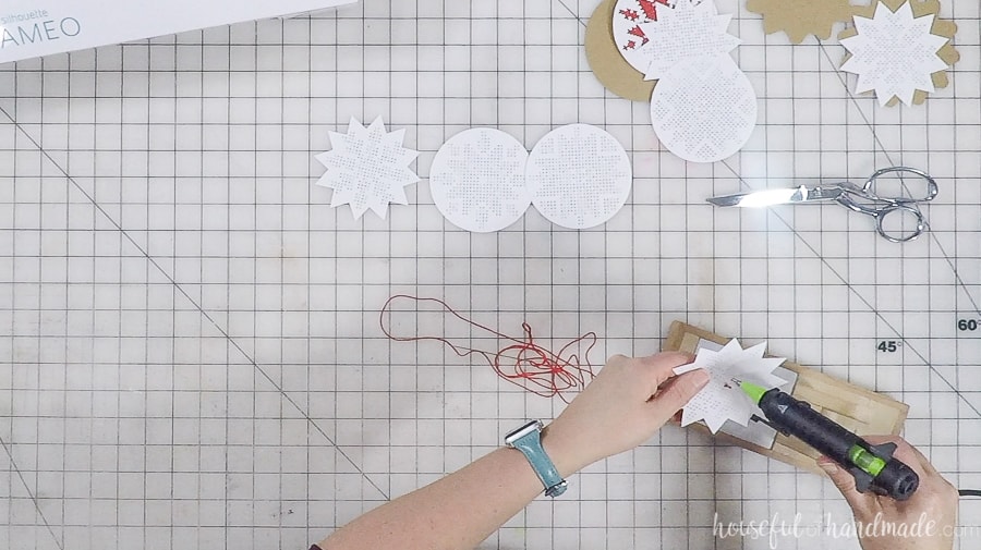 Securing the glue on the back of the ornament with hot glue.