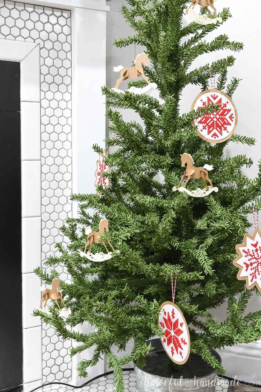 Mini Christmas tree decorated with paper rocking horse ornaments and cross-stitch Nordic snowflakes.
