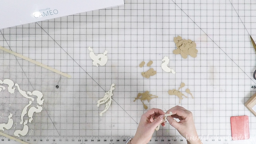 Pieces of the paper rocking horse ornaments on a work table.