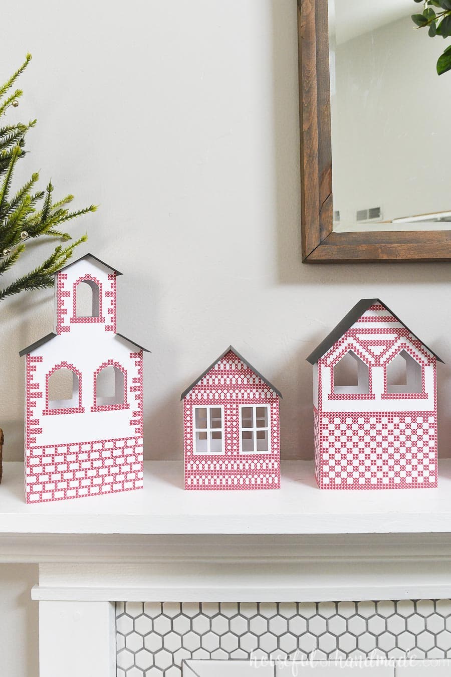 Three paper Christmas houses with red details, including a simple church.