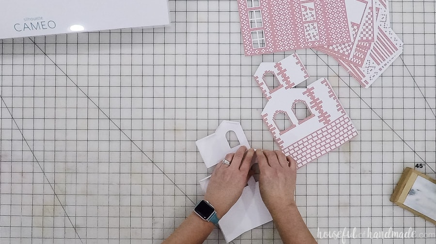Folding along all the dotted lines on the Christmas village templates.
