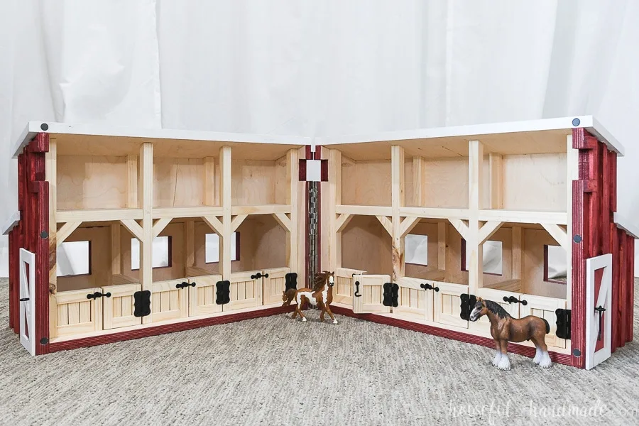 Wooden toy barn opened up to expose 6 horse stalls and loft area. 