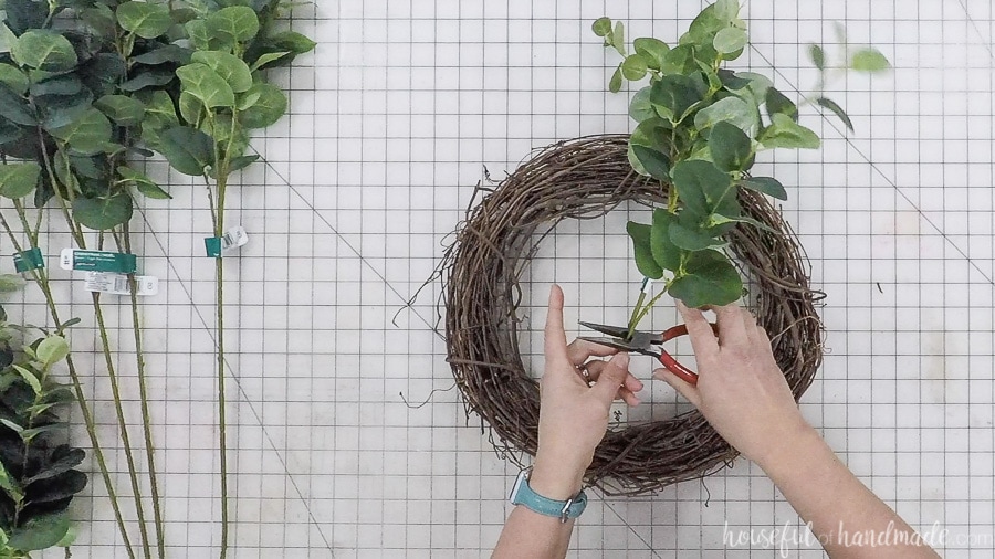 Cutting faux eucalyptus stems with wire cutters.