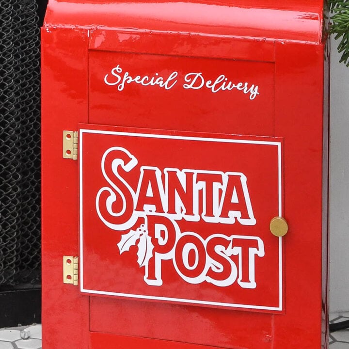 Close-up of the shiny red DIY Santa's mailbox with vinyl Santa Post design on the door.