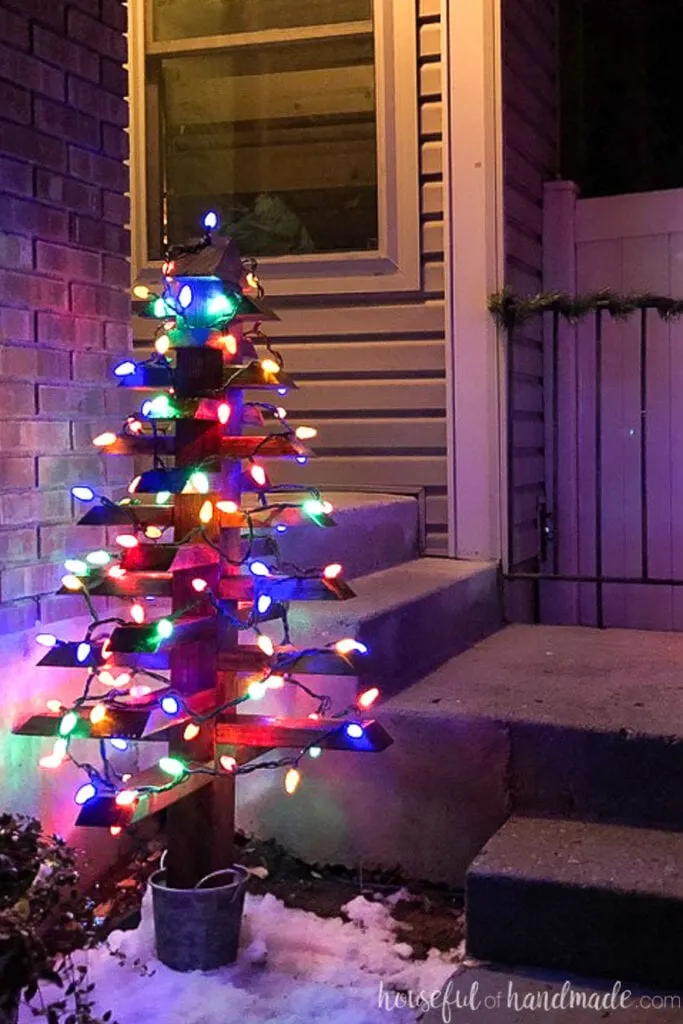 Close up of the larger 2x4 outdoor Christmas tree with lights on at night. 