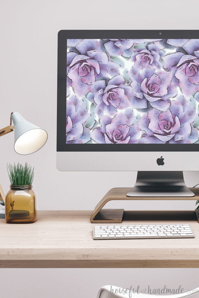 iMac computer on a desk with digital wallpaper for January on the background.