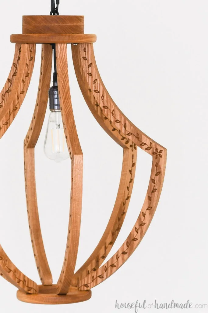 Close up shot of the carved flower and leaf design on the sides of the DIY wood chandelier.