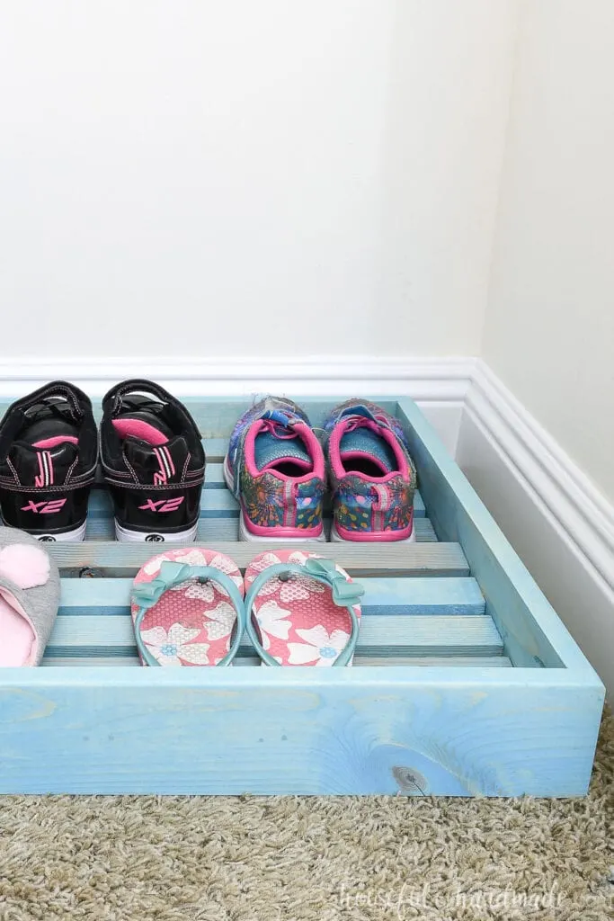 Side of the closet shoe organizer with shoes on the rows. 