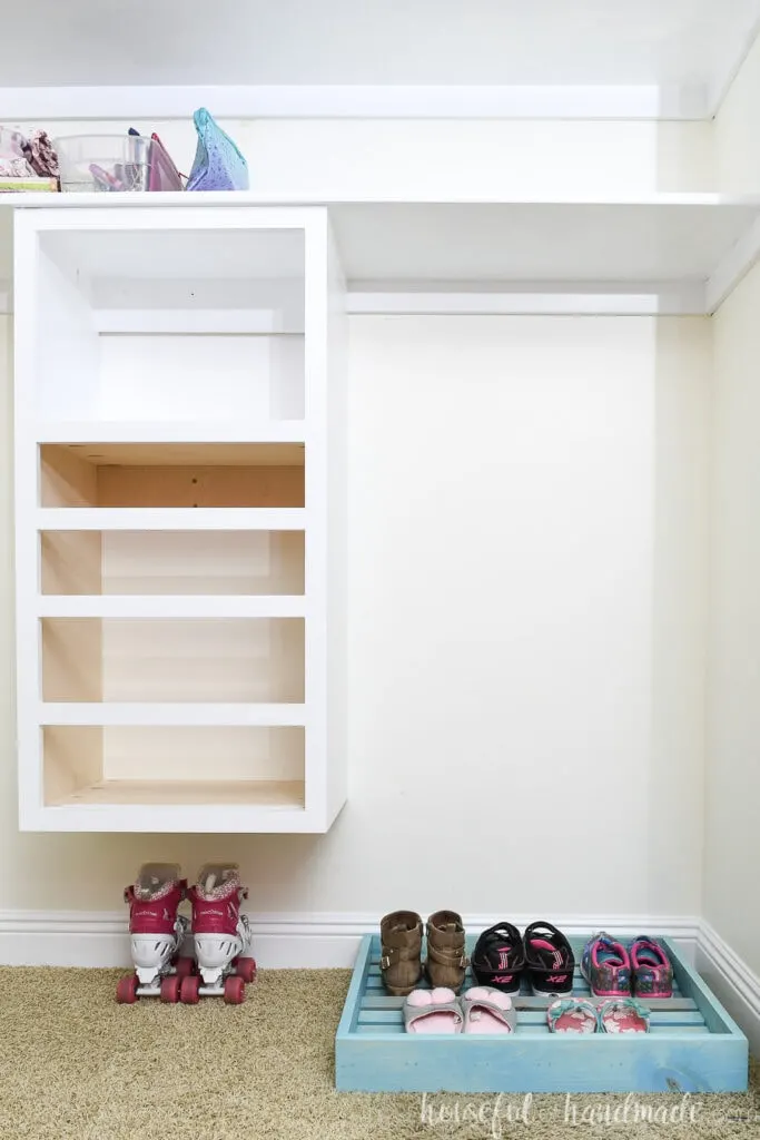 Closet makeover on week 3 with closet organizer installed and painted and shoe organizer tray on the floor. 
