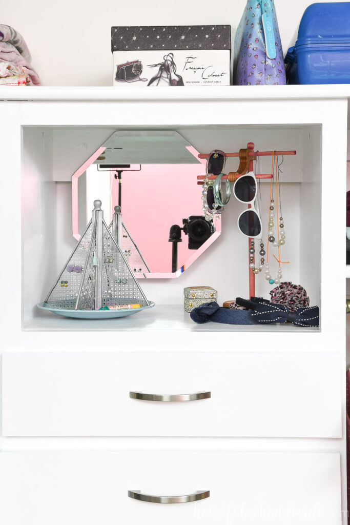 The top shelf of the closet organizer with jewelry organization for a girl. 