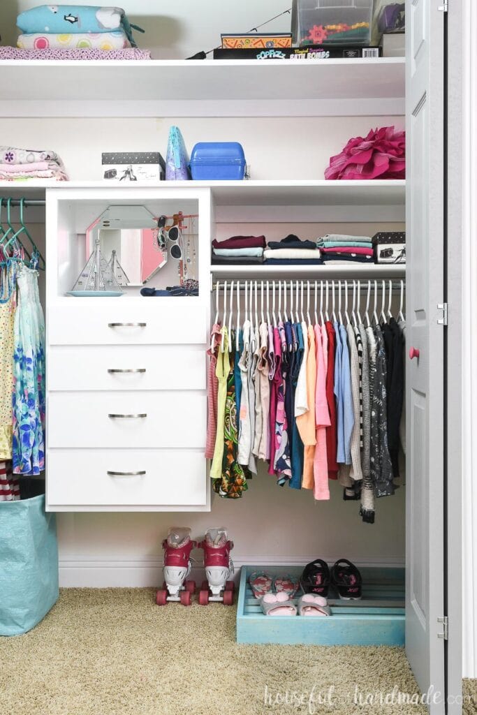 Full view of the organized girl's closet with shoe storage and closet organizer. 