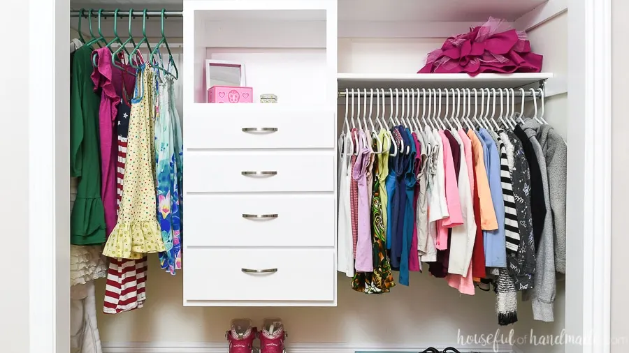 Kids closet organized with double hang bars and a DIY closet organizer in the center. 