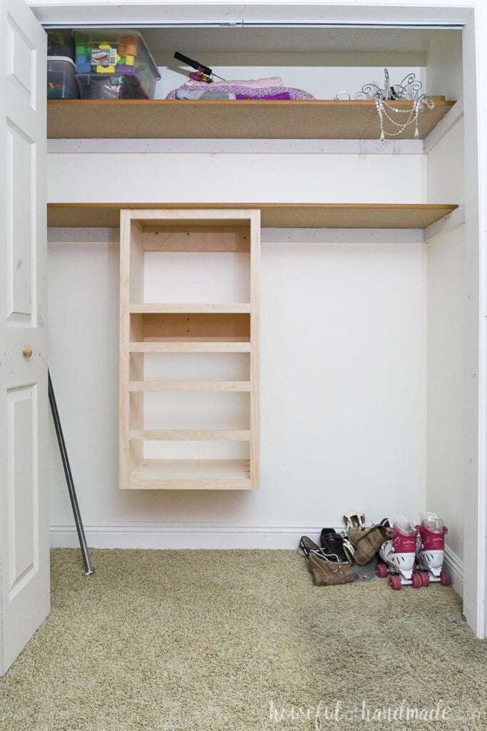 Kids closet cleared out of clothes with a DIY closet organizer added below the shelf. 