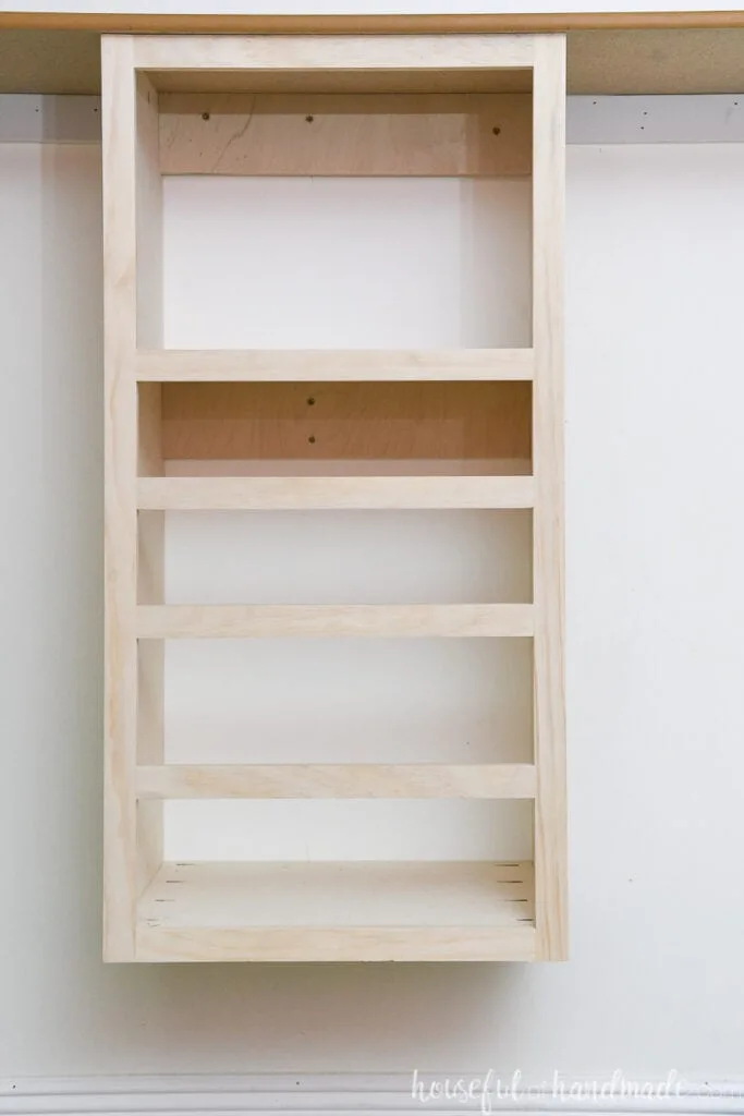 Close up of the DIY closet organizer frame installed in the closet under the shelf. 