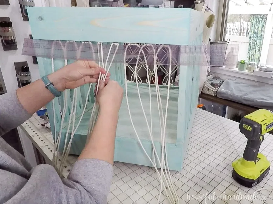 Starting the macrame net on the storage bin with the 4 center cords. 