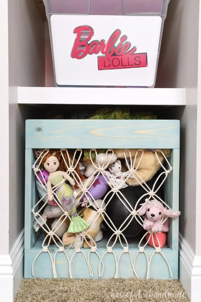 Shelving nook next to closet with Barbie bin and DIY stuffed animal storage with macrame front in it.