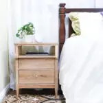 DIY tall nightstand with 2 drawers with inset drawer fronts next to a bed.