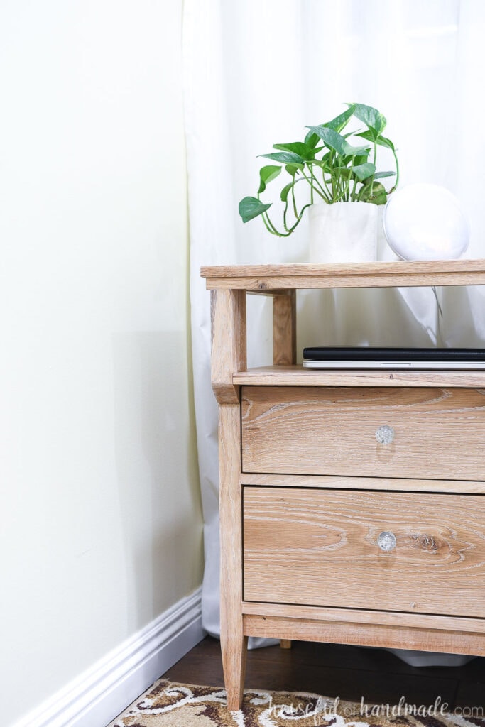 Side view of the DIY nightstand with a plant on top.