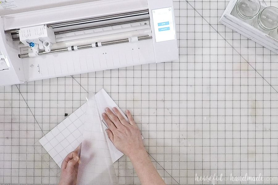 Removing cut out paper from the cutting mat in front of the Silhouette Cameo machine.