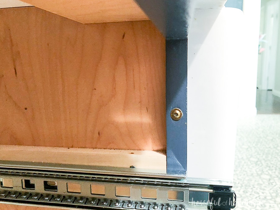 Close up view of the cabinet screw in the side of the face frame holding the cabinets together. 