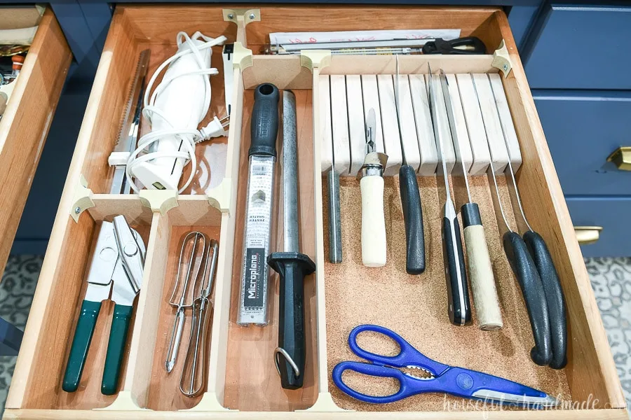 Drawer organized with wood strips and knife block. 