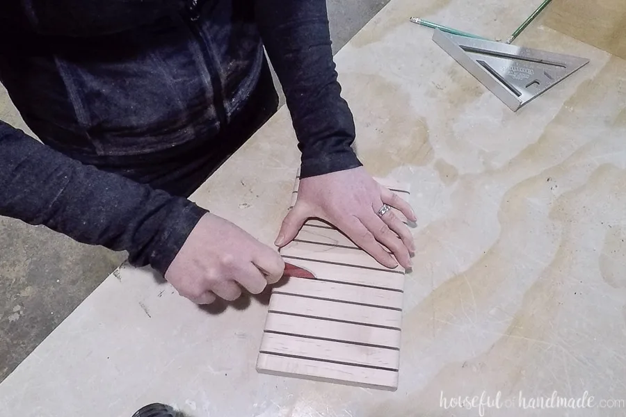 Sanding inside the knife block grooves by hand with a piece of folded sandpaper. 
