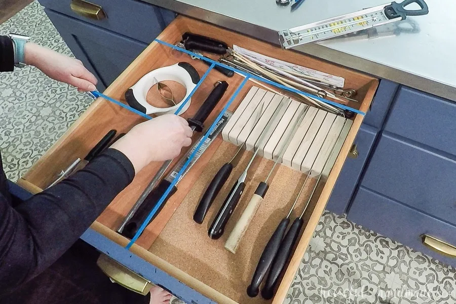 Laying out the utensils in the drawer and defining the drawer divider configuration with 1/4" blue tape.