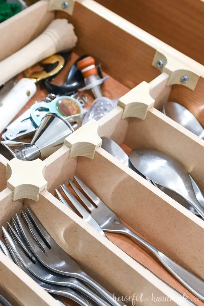 Close up of the T, X, and end cap clips on the wood drawer organizer. 